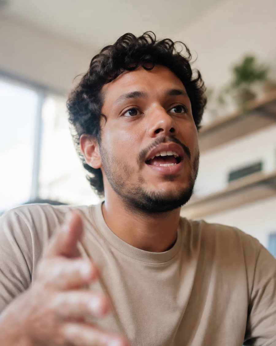 Participante em pé no meio da roda, segurando a folha de anotações enquanto fala